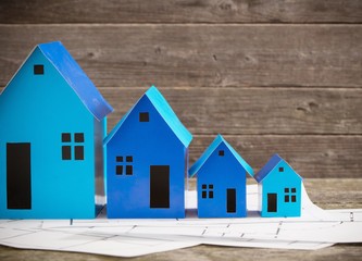 A paper houses stands over a wooden background