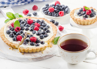 Cheese cake with berries cup of hot tea.