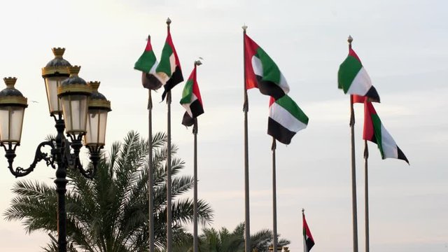 Flags of UAE waiving on the wind in day time.