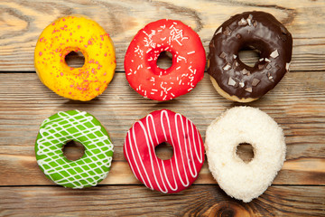 Colorful donuts on wooden background