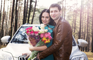 Man and girl with flowers near the car