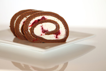 Chocolate roll with raspberries and vanilla cream 