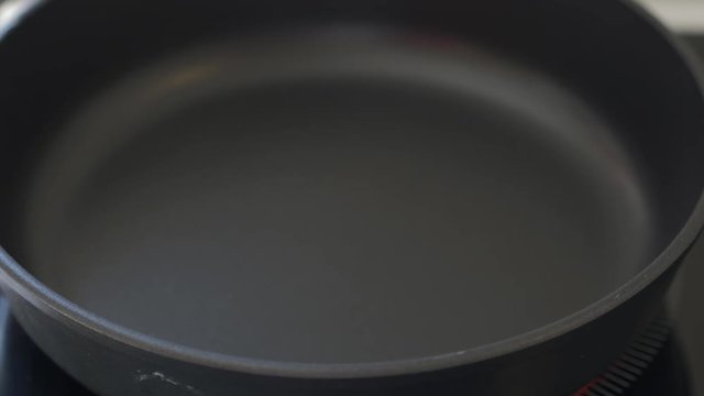 
Pouring oil into frying pan ready for frying. Selective focus.