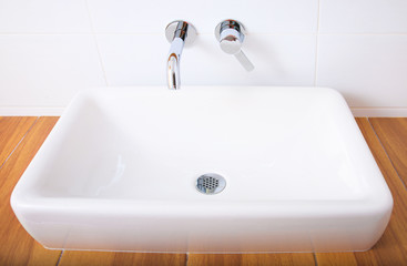 White porcelain washbasin and chrome-plated faucets.