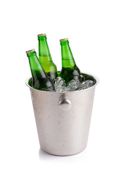 cold bottles of beer in bucket with ice on white background.