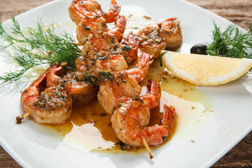 Japanese cuisine. Delicious shrimps served with herbs and lemon on white plate, close up view. Restaurant menu photo.