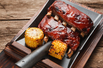 Delicious grilled pork ribs with corn served on shovel, top view. Restaurant menu photo. Chinese cuisine.