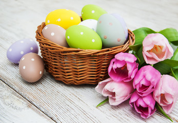 Fototapeta na wymiar Basket with easter eggs and tulips