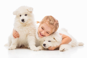 Little girl with a samoyed puppies