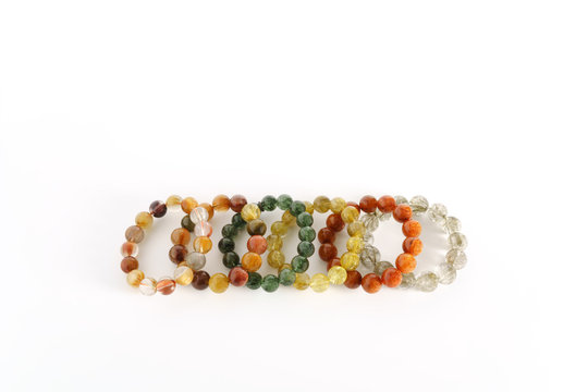 Beautiful translucent assorted colors Rutilated Quartz or Venus’ hairstone bead in bracelets on white background
