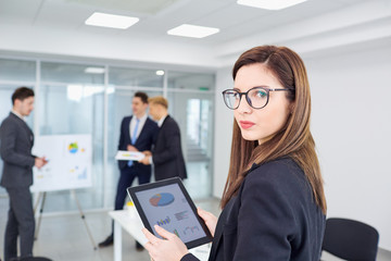 Young girl in glasses with  businessman with a tablet in the office.