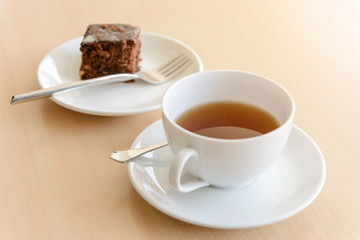 cup of hot tea with brownie on wooden table