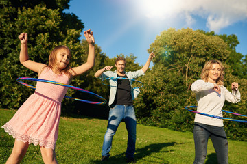 Fun loving family playing with hula hoops together outside