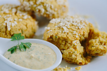 Falafels coated with white sauce, close up
