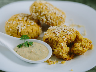 Falafels coated with white sauce, close up