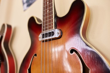  Old excellent electro and bass guitars on the shelf in the guitar shop