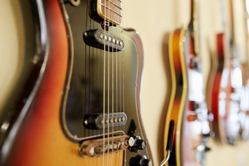  Old excellent electro and bass guitars on the shelf in the guitar shop