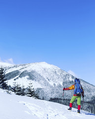 Winter hiking in the mountains on snowshoes with a backpack and tent.