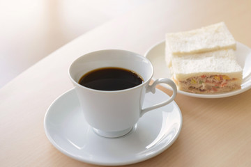 hot coffee with sandwich on wooden table