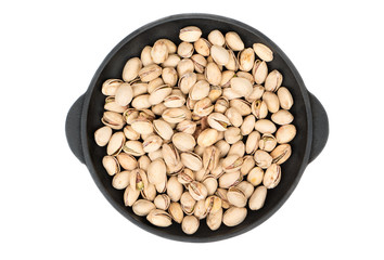 Pistachio nuts in frying pan isolated on white background, top view