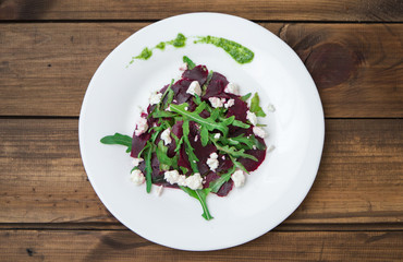 Salad with beet, feta, arugula and pesto.