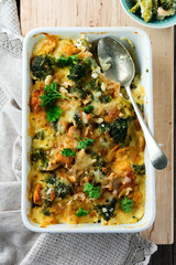 Graten from broccoli, chicken and spices with cheese sauce in white ceramic form. Selective focus.Top view.
