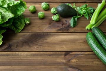 Products containing folic acid - B9 vitamin . Green vegetables on wooden background. Celery, avocado, Brussels sprouts, basil, cucumber, romaine salad