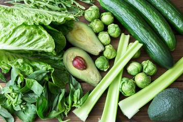 Products containing folic acid - B9 vitamin . Green vegetables on wooden background. Celery,...