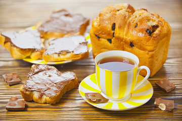 delicious tea with bread and chocolate paste on wooden