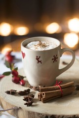 Heiße Schokolade in einer weihnachtlichen Tasse auf Holzscheibe