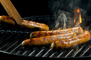 Succulent sausages grilling on a BBQ fire