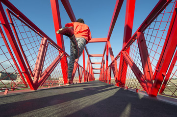 Young man running on the red bridge