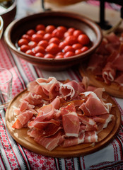Slices of ham served on round wooden plate