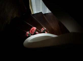 Look from wooden spiral stairs at pink bouquets lying on them