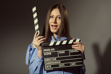 Close-up of a young women with movie clapper