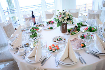 Table number 1 served with white plates and dishes with snacks, fish and meat