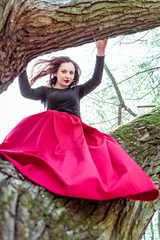 Fototapeta premium beautiful young woman on tree trunk