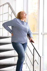 Senior woman suffering from backache while walking downstairs