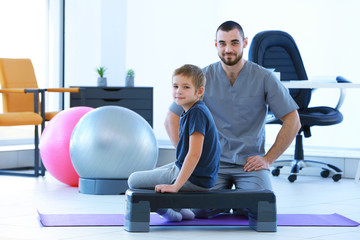 Physiotherapist and little boy in clinic
