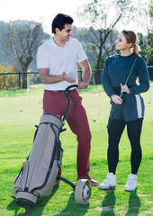 Fototapeta premium Male and female golfers ready for team play at golf course