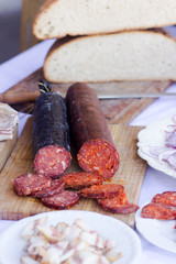 red sliced sausage on wooden board