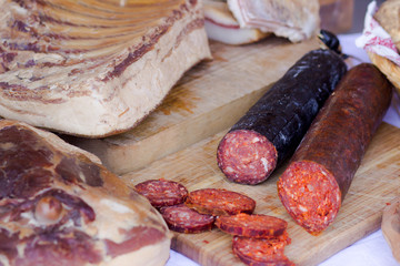 red sliced sausage on wooden board