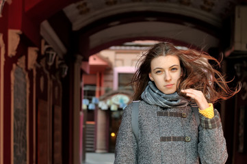 Girl comes out of the dark arch and the wind blows her hair