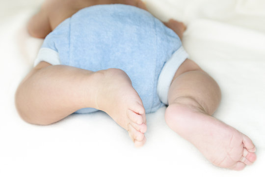 Bauch, Beine und Füße eines kleinen Babys mit Stoffwindel
