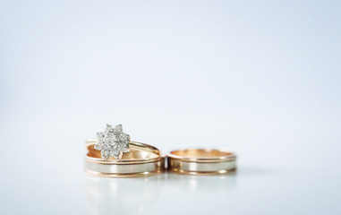 Golden wedding and proposal rings lie on table
