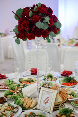 Number 4 put in golden frame stands on dinner table served with snacks and salads