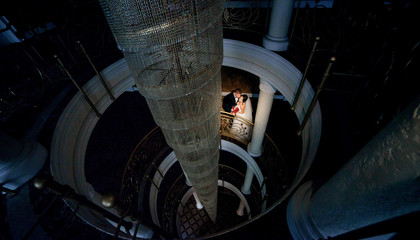 Fototapeta premium Look from above at wedding couple standing on spiral stairs