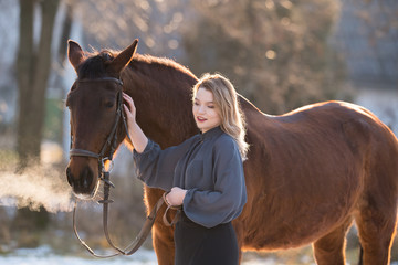 Young beautiful elegance woman posing with horse