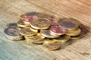 Euro coins piled on wooden table