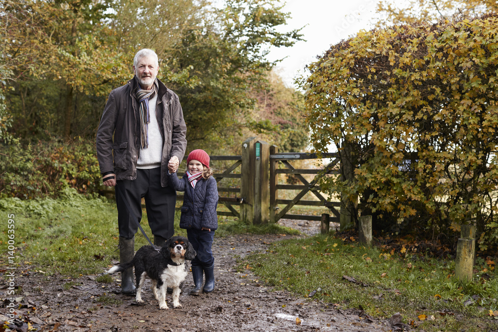 Wall mural grandfather and granddaughter taking dog for walk